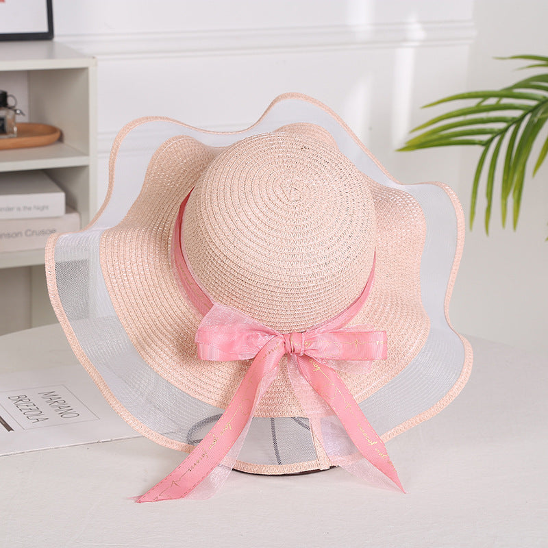 Elegant ladies mesh straw hat with a big brim and pink ribbon, providing sunshade and a stylish look.