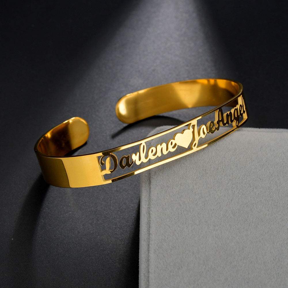 Gold customized name bracelet with heart design on stainless steel.
