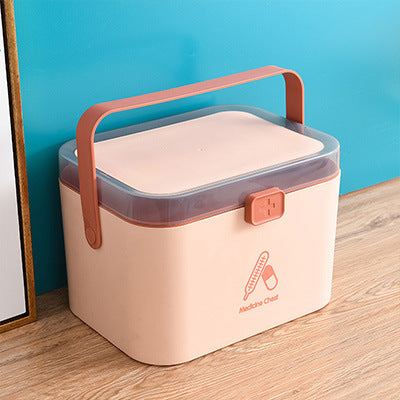 Portable double-layer medicine box in Nordic pink with handle on wooden surface.