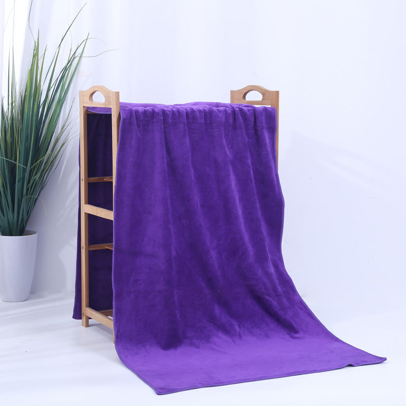 Microfiber thickened car wash cleaning towel in dark purple hanging on a wooden rack.