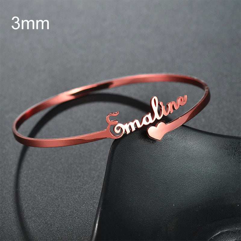 Customized name bracelet with heart charm in rose gold stainless steel.
