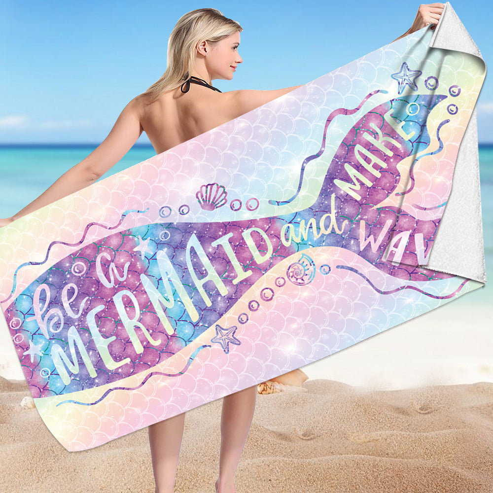 Microfiber bath towel with mermaid design on a sandy beach background.