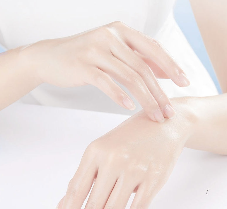 Gentle hands applying moisturizing hand mask for hydration.