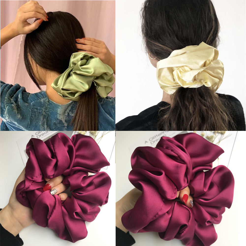 Oversized smooth satin scrunchies in various colors worn as hair accessories.