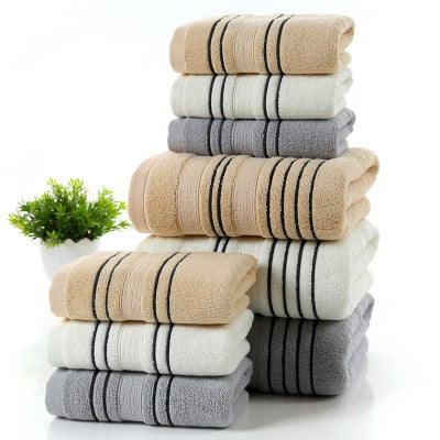 Household pure cotton towels stacked in mixed colors: white, gray, and khaki.