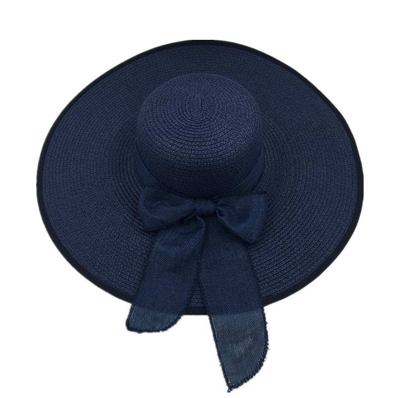 Navy blue ladies foldable sun protection straw hat with big brim and ribbon.