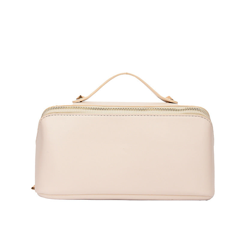 Cosmetic bag women's large capacity in solid pink color with handle, synthetic leather, ideal for portable skincare storage.
