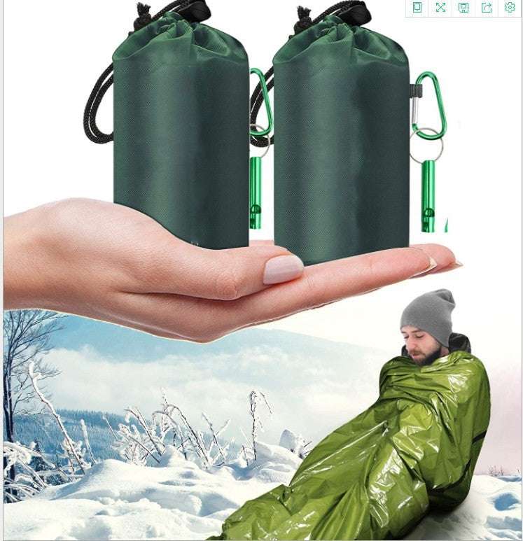First aid sleeping bag with green cover shown in snowy outdoor setting.