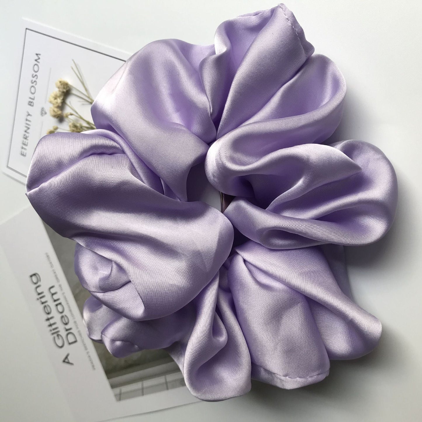 Oversized smooth satin large intestine circle hair tie in light purple.