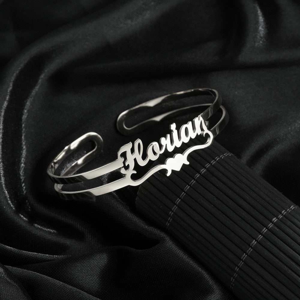 Stainless steel customized name bracelet in silver on black background.