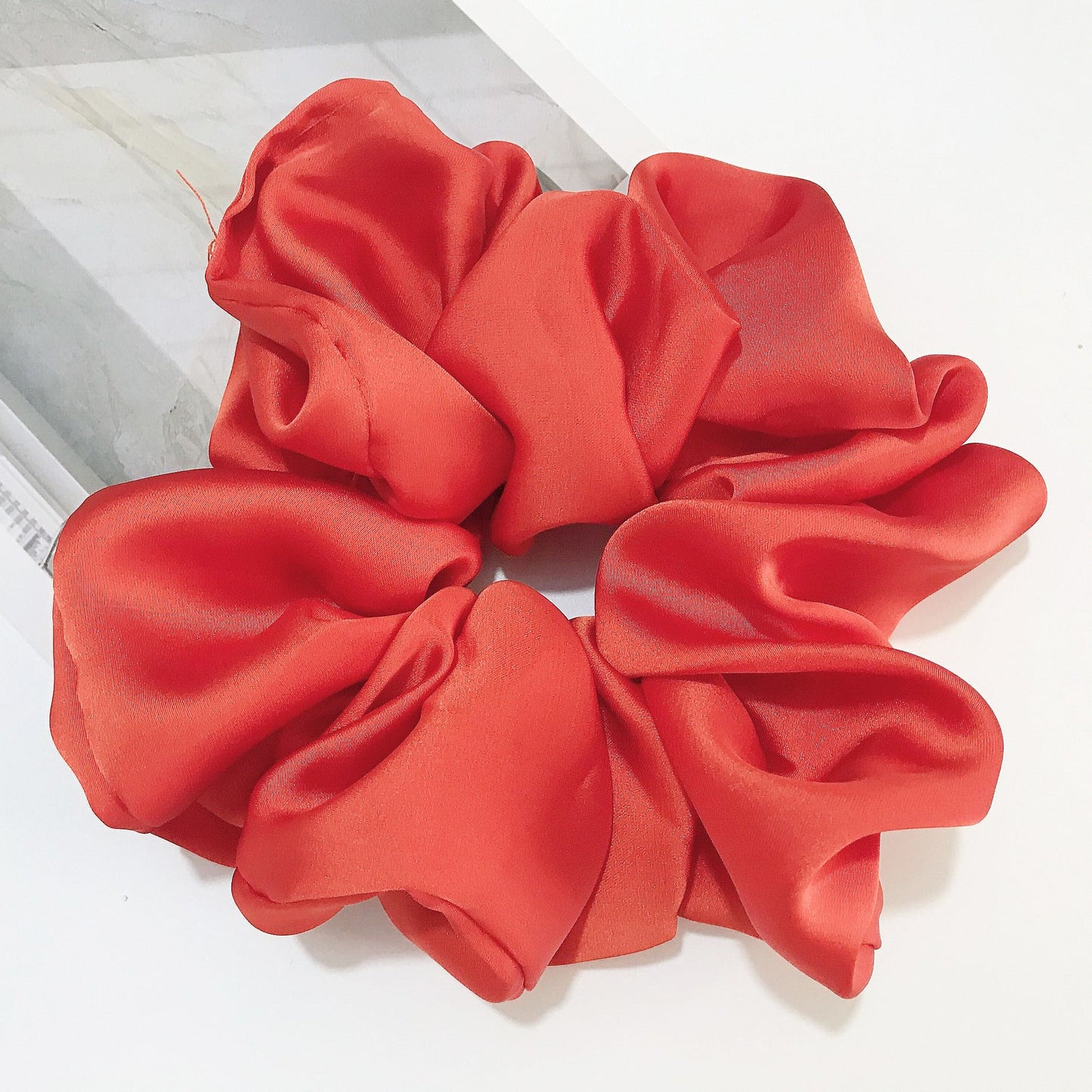 Oversized smooth satin large intestine circle hair tie in vibrant red color, showcasing a handmade design.
