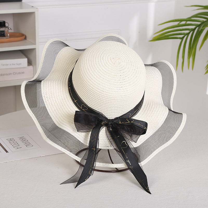 Elegant ladies mesh straw hat with a big brim, adorned with satin streamers, in milk white color.