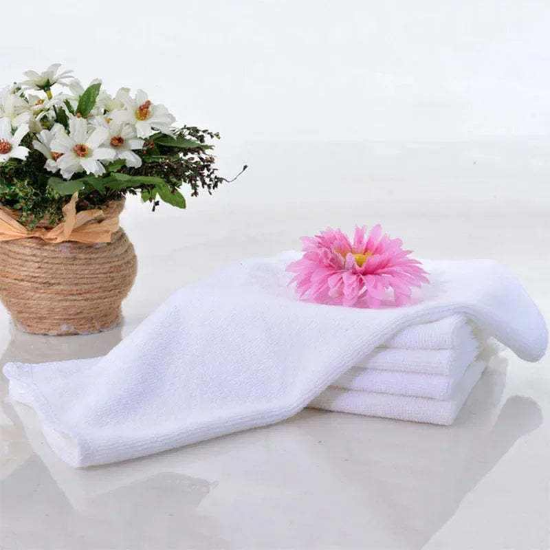 Absorbent thickened microfiber towel in white, displayed with decorative flowers.