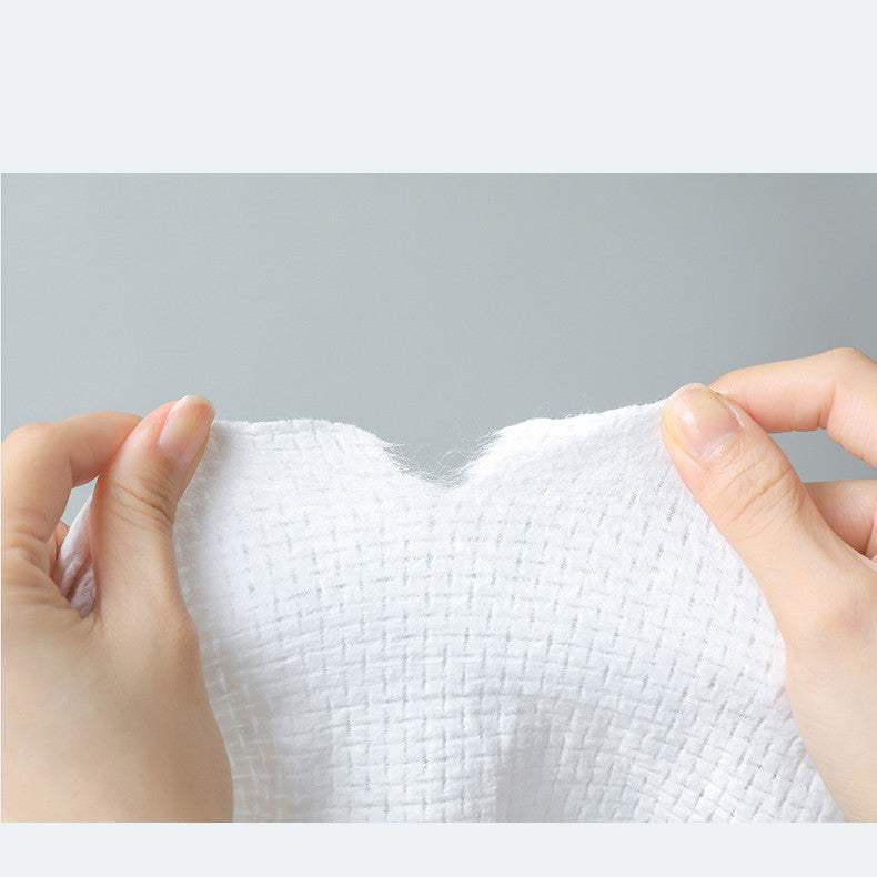 Compressed towel being stretched by hands, showcasing its texture and flexibility.