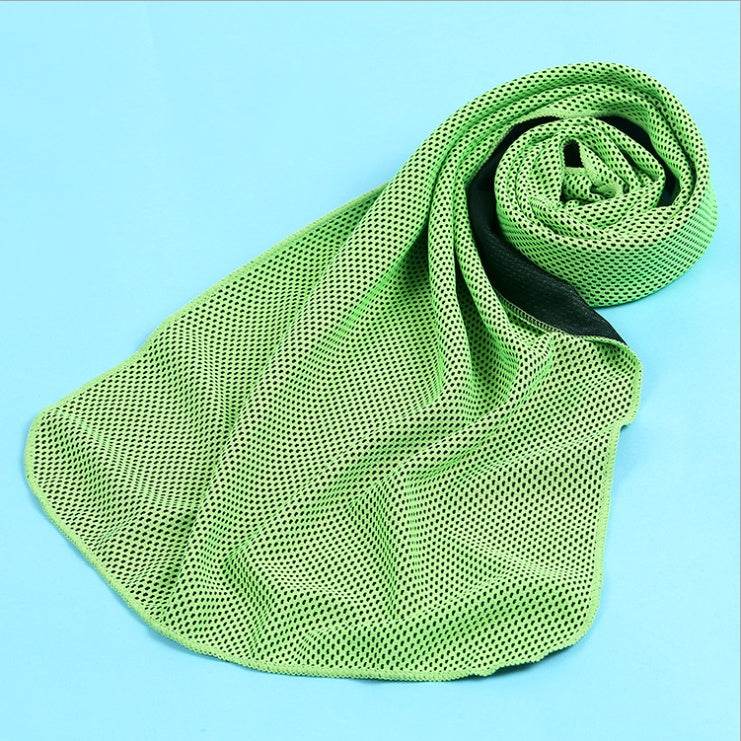 Green cooling towel made from polyester, rolled on a blue background.