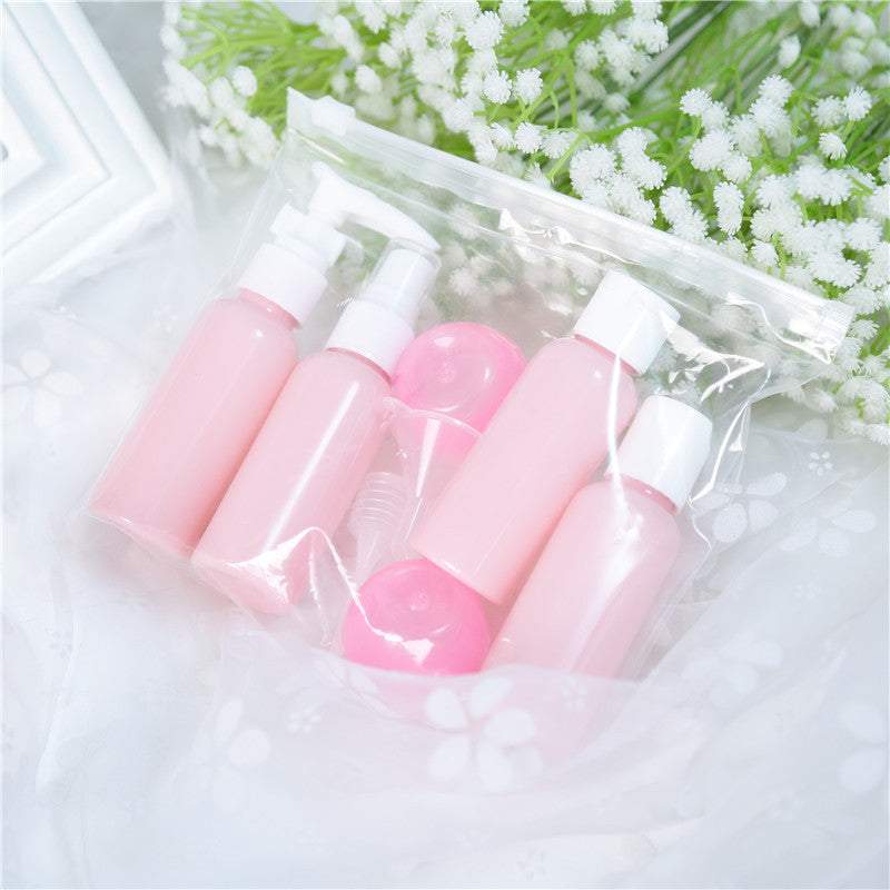 Cosmetic bottling set with pink plastic bottles for lotion and spray in a clear pouch.