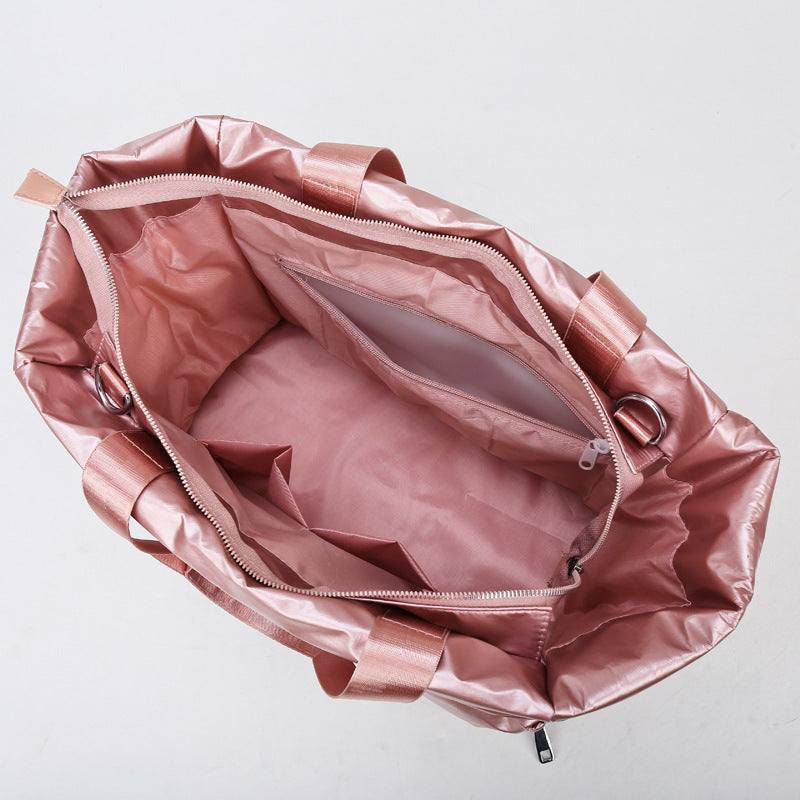 Women's gym bag in pink nylon with spacious interior and multiple pockets, ideal for fitness and travel.