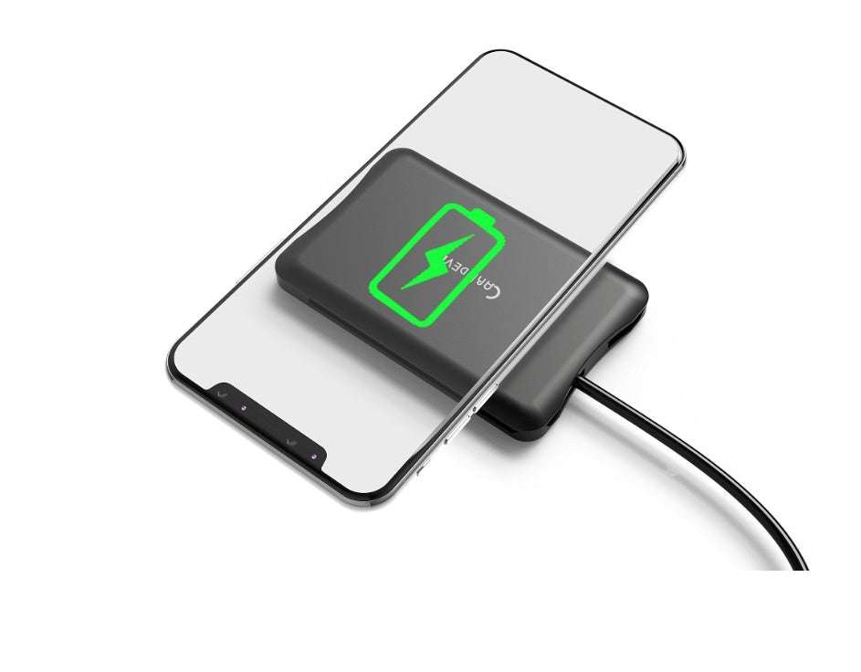 Multifunctional travel survival card with wireless charging feature under smartphone display.