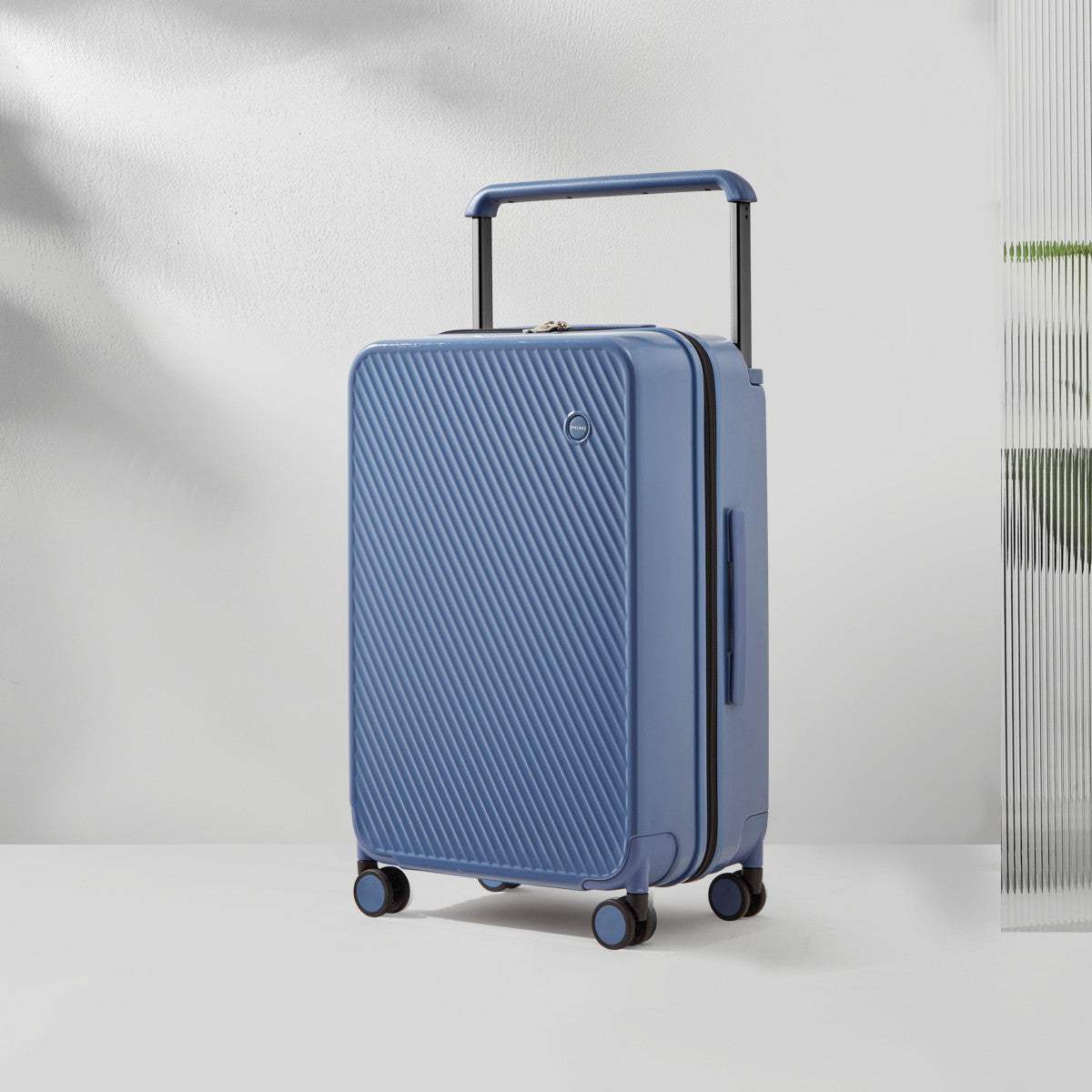 Wide trolley case with large capacity in solid blue color, featuring durable PC texture and zipper closure.