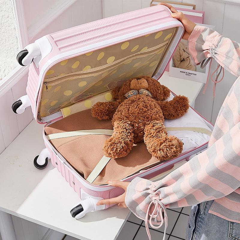 Schoolgirl fashion cute pink trolley case with open lid and teddy bear inside.