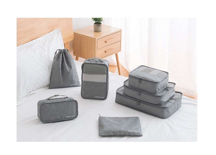 Waterproof travel tote bag set of 7 in gray displayed on a bed.