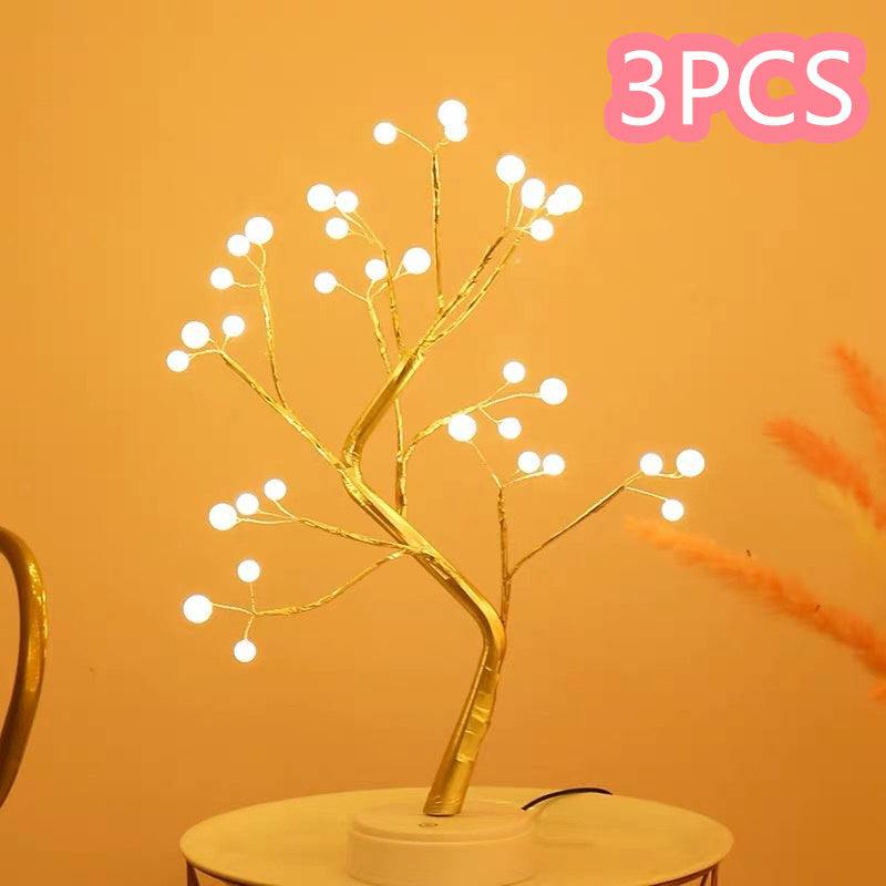 LED copper wire light shaped like a glowing golden tree with multiple white LED bulbs on branches, placed on a table against an orange background