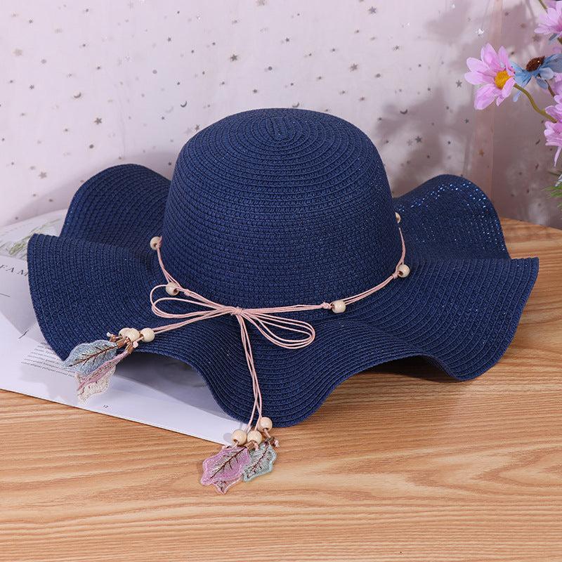 Ladies big brim wave straw hat in navy with bow and dome style, perfect for outdoor shade.
