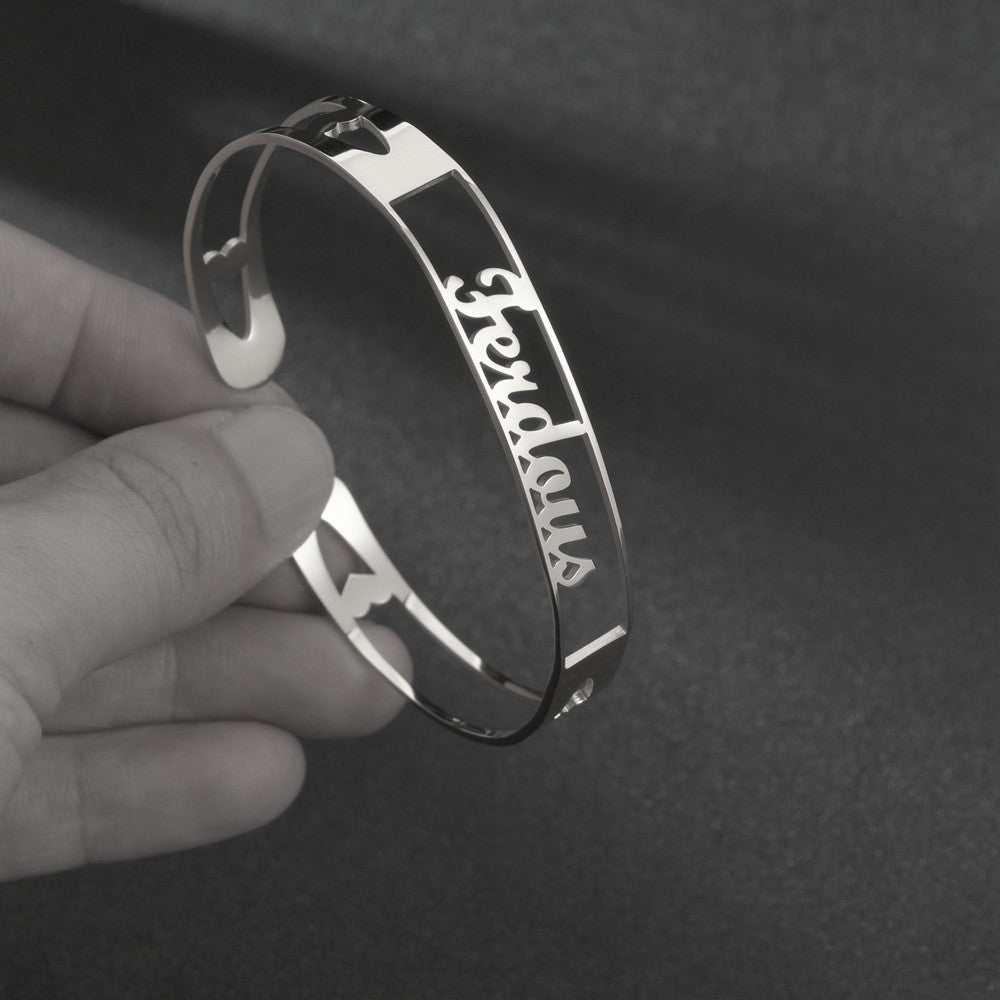 Customized silver name bracelet in stainless steel with personalized engraving.