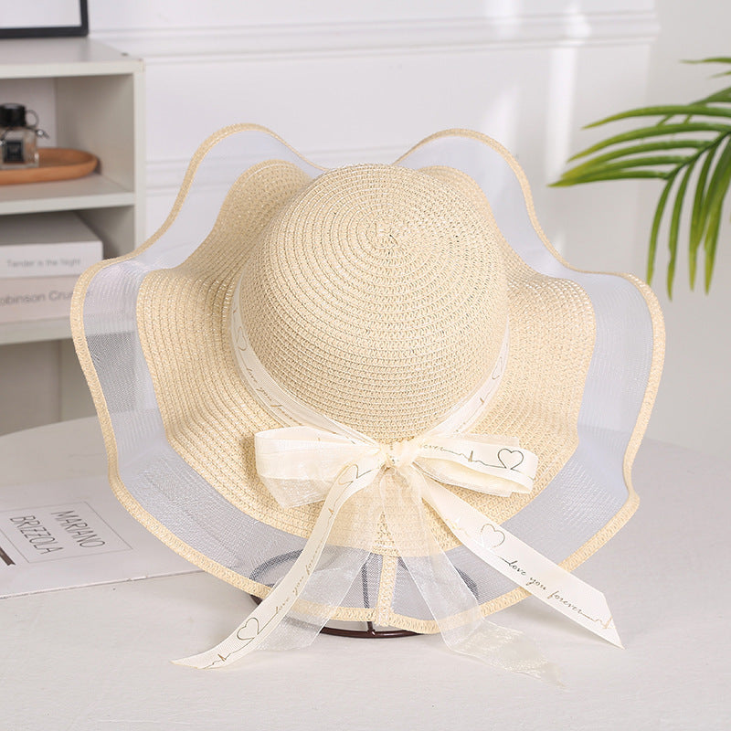 Elegant ladies mesh straw hat with a big brim featuring a satin bow, ideal for sun protection.