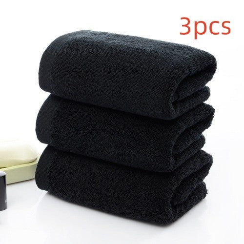 Three black cotton towels, each made from 21 strands, stacked neatly against a light background.
