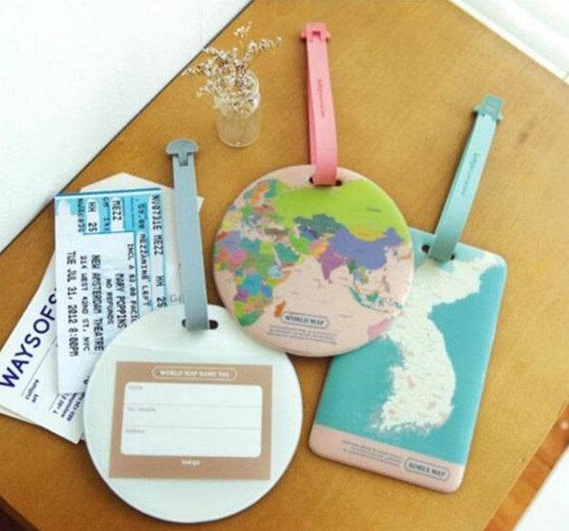 Luggage tags with cartoon designs and straps on a table near boarding passes.