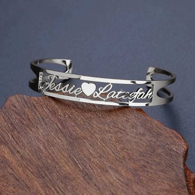 Customized name bracelet with heart detail in stainless steel.