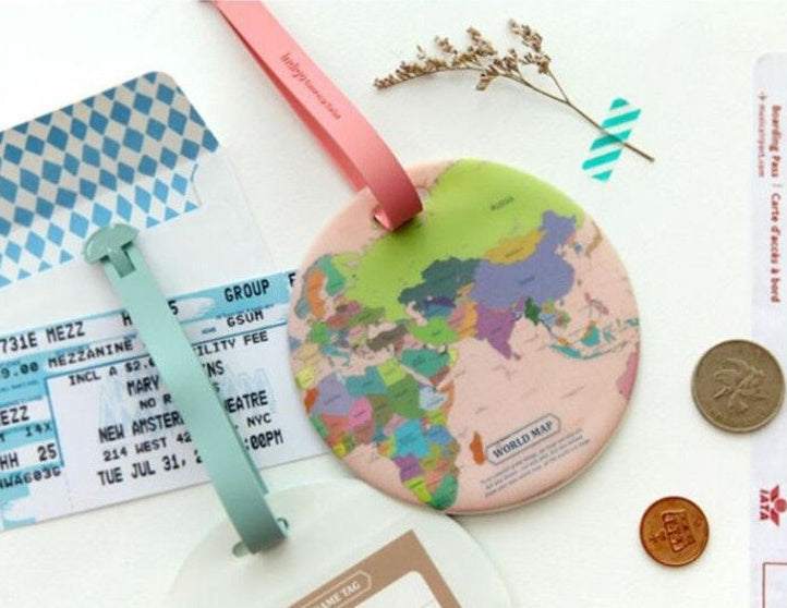 Luggage tag with colorful world map design and suitcase strap.