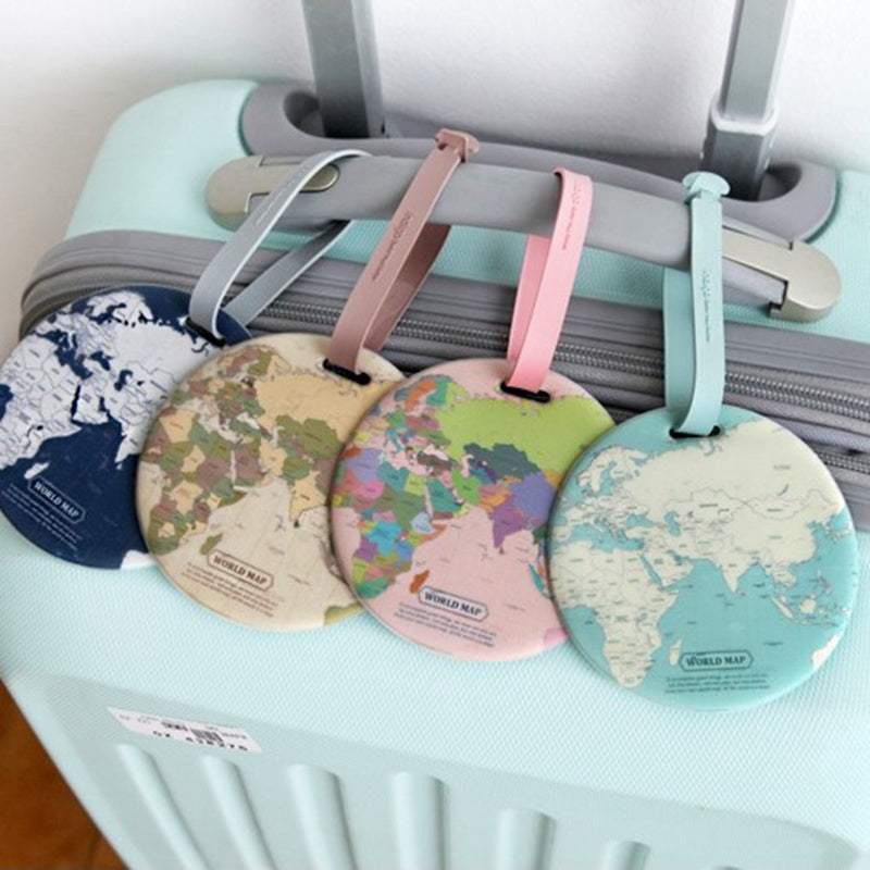 Luggage tag with cartoon design hanging from suitcase strap.