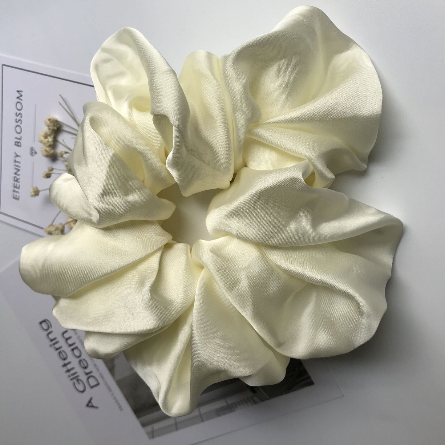 Oversized smooth satin large intestine circle hair tie in milky white.