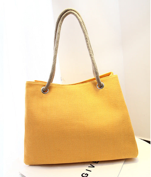 Large capacity Korean style yellow shoulder bag with woven handle.