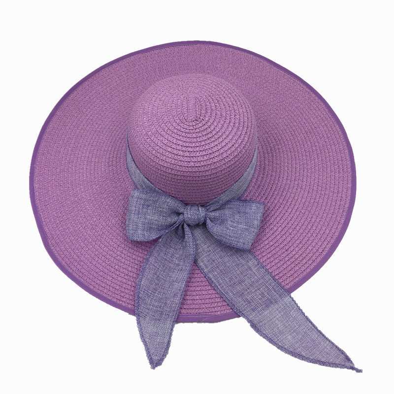 Ladies foldable sun protection shade hat with big brim in purple straw, featuring a bow.