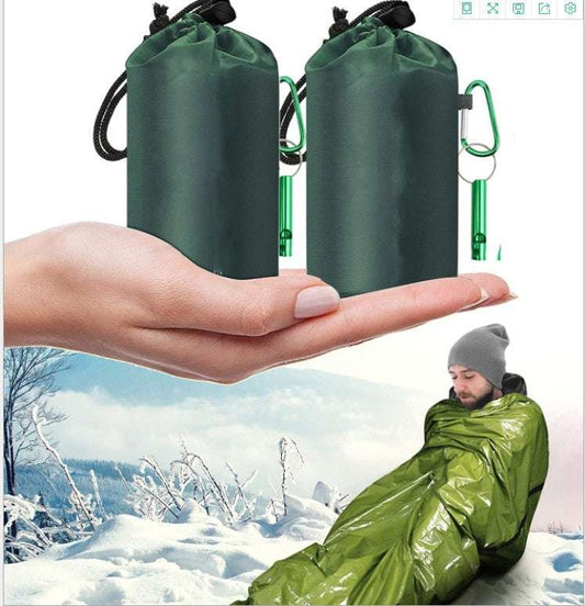 First aid sleeping bag with green cover shown in snowy outdoor setting.