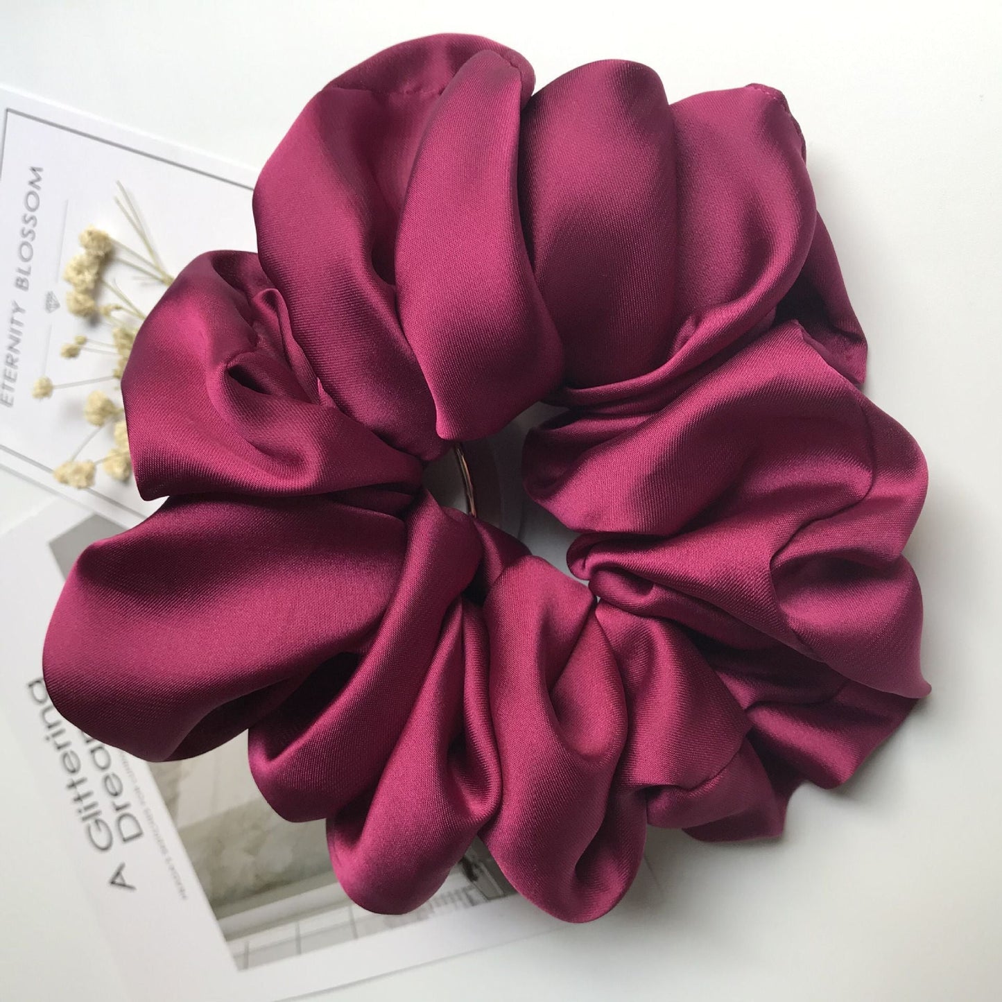 Oversized smooth satin large intestine circle hair tie in deep red color.