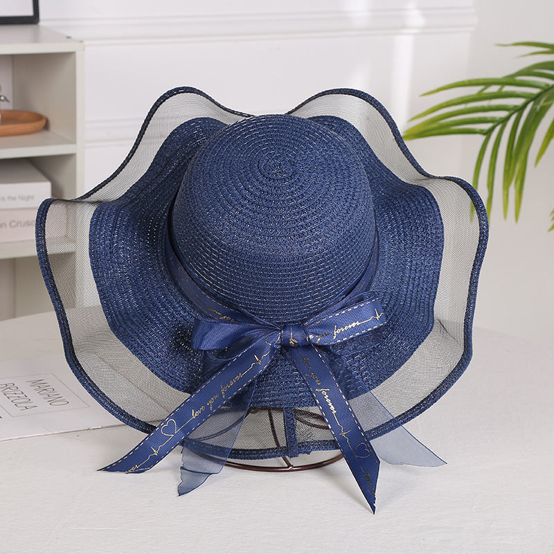 Elegant ladies mesh straw hat with big brim in navy blue, featuring satin streamers, perfect for sun protection.