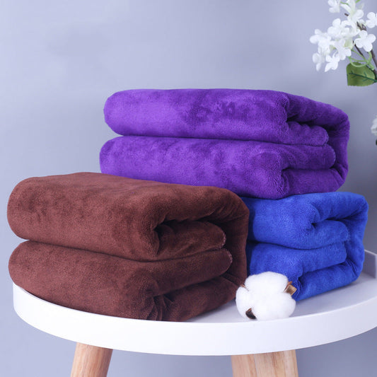 Microfiber thickened car wash towels in brown, dark blue, and dark purple stacked on a table.