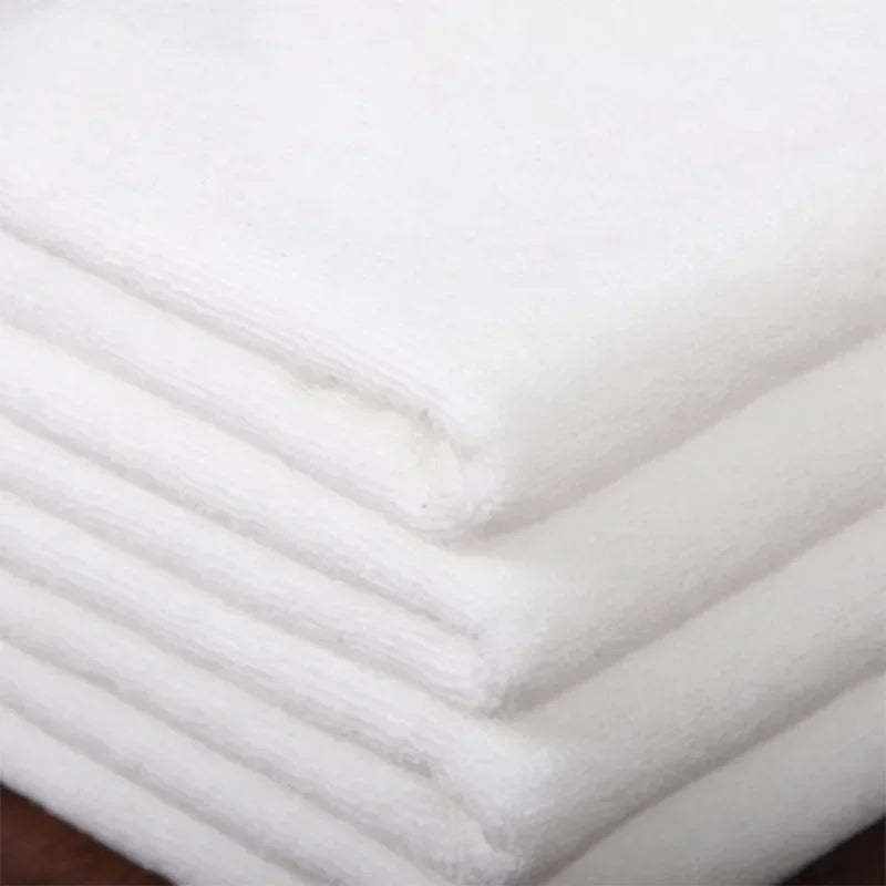 Absorbent thickened hotel towel, white microfiber, stacked neatly.