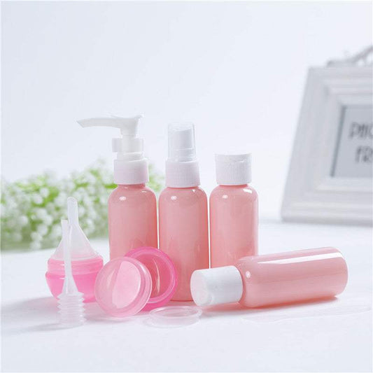 Cosmetic bottling set with pink PET plastic bottles for lotion, shampoo, and cream.