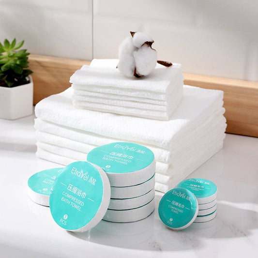 Disposable compression towel set with stacked white towels and packaged compressed towels, featuring polyester and polyamide blend.
