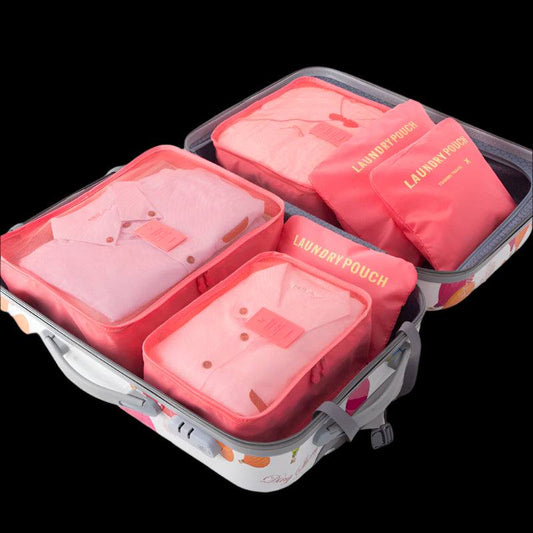 Packing bags in pink shades neatly arranged in a suitcase.