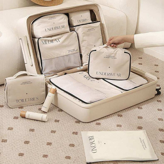 Travel storage bag set with various sizes, including pillow style, clothing, and shoe bags, neatly packed in a suitcase.
