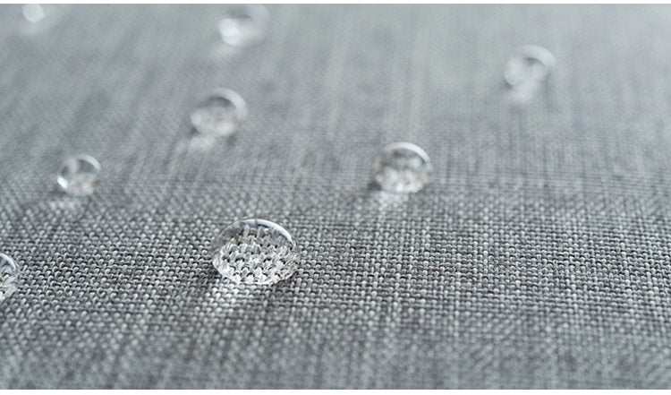 Water droplets on waterproof fabric of gray travel tote bag.