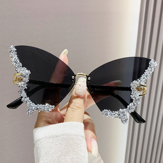 Luxury diamond butterfly sunglasses with oversized rimless design and decorative crystals.