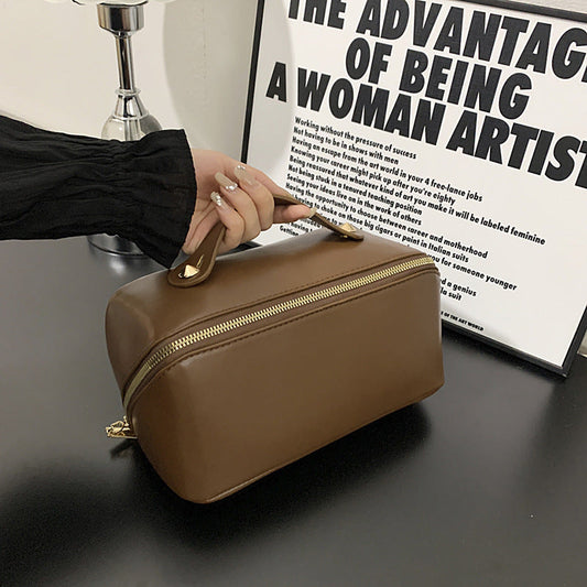 Large capacity cosmetic bag in dark brown PU leather with gold zipper, suitable for home storage and both men and women.