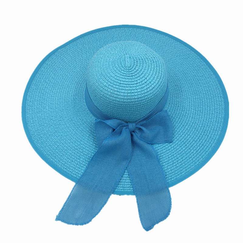Ladies foldable blue straw sun hat with big brim and bow detail.